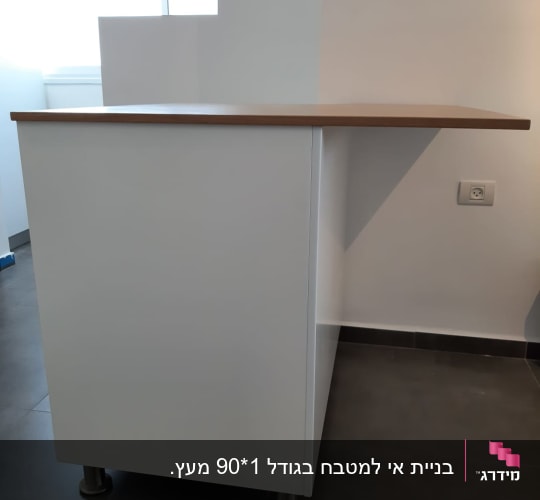 אי מטבח לבן עם משטח עבודה ודלפק עץ